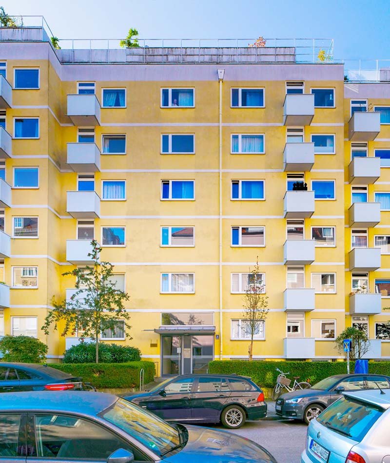 Mehrfamilienhaus mit Autos auf Straße